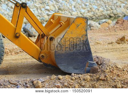 Bucket of front-end loader pushing dirt while working on a new road near Songkhla, Thailand