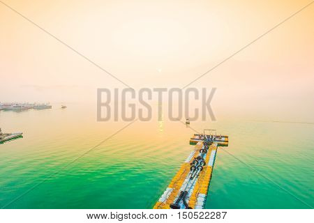 SUN MOON LAKETAIWAN - MARCH 21: Fog with many boats parking at the pier while sunrise on MARCH 21 2015 at Sun Moon Lake Taiwan. Sun Moon Lake is the largest body of water in Taiwan with nataral place.