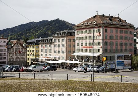EINSIEDELN SWITZERLAND - MAY 09 2016: Colorful facades of buildings and cars on a street shows the town that is often visited by pilgrims and tourists because of the widely known Einsiedeln Abbey