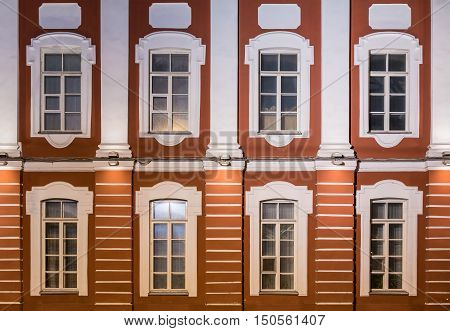 Several windows in a row on night illuminated facade of Saint Petersburg State University front view Russia