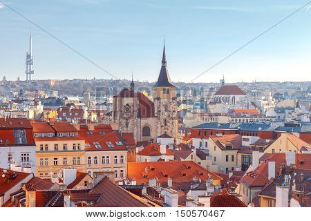 Aerial view of the historic center of Prague with towers, spiers and red-tiled roofs.