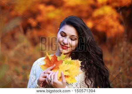 portrait of a beautiful girl with maple yellow leaves