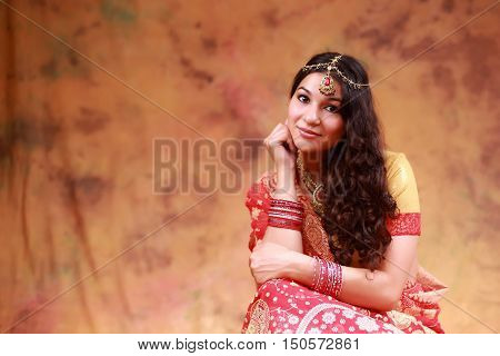 beautiful Indian woman in a sari traditional dress on an abstract yellow background