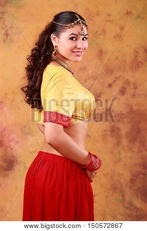 beautiful Indian woman in a sari traditional dress on an abstract yellow background