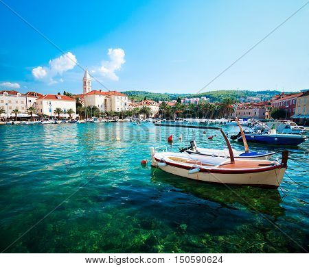 Supetar, Brac Island. Medieval Mediterranean Town in Croatia. Clear Azure Water. Popular Touristic Destination of Dalmatia Region at Adriatic Sea. Toned Photo with Copy Space.