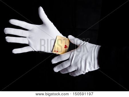 Playing cards trick with ace hands with gloves on black background