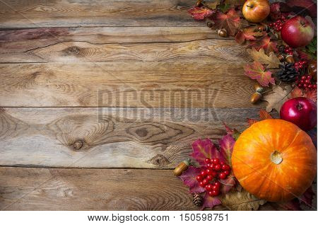 Thanksgiving or fall greeting background with pumpkins and fall leaves. Thanksgiving background with seasonal vegetables and fruits. Fall background. Copy space