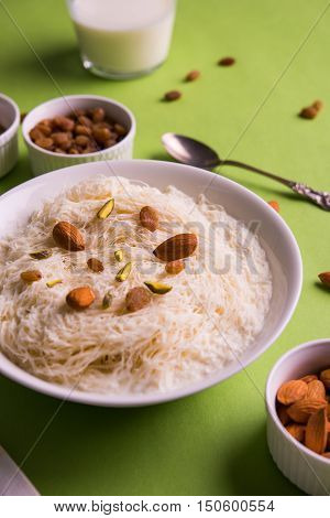 Indian sweet sutarfeni or sutar feni or firni or seviyan or laccha, shredded, flaky-rice-flour roasted in ghee, blended with melted sugar to form a cotton candy, topped with pistachio and almonds