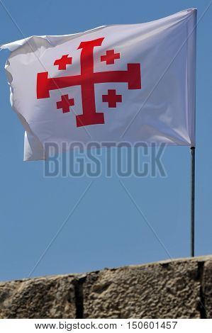 A Crusader flag of Jerusalem at Mount Tabor Israel. The cross of the Holy Land a Greek cross in red on a white background also known as the "Jerusalem cross" is the symbol of the Custody of the Holy Land.