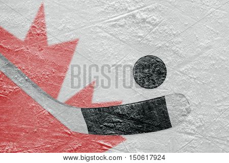 Hockey puck hockey stick and Canadian flag image on ice