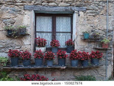Spanish window containing geraniums in Beget, a medieval village in the Pyrenees, Catalonia, Spain