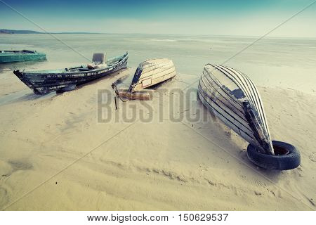 Old wooden Boat on the beach during sunrise