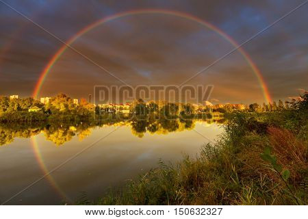 Rainbow abowe lake on an autumn day close to sunrise or sunset.