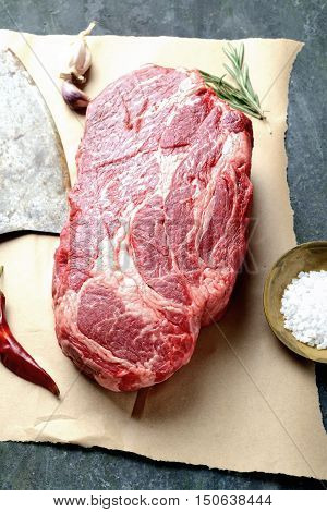 veal steak marbled paper, knife for meat, rosemary, pepper and salt