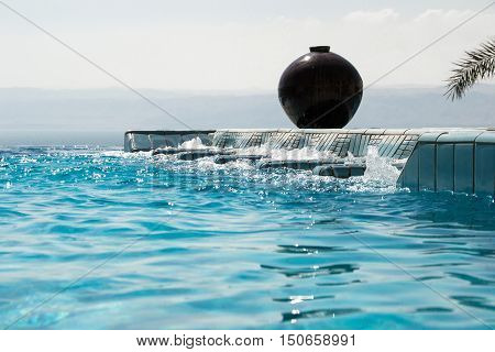 Photo of the Infinity pool  with azure water. Luxury lifestyle, recreation concept.