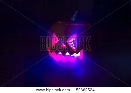 luminous halloween traditional pumpkin in the dark on the black background