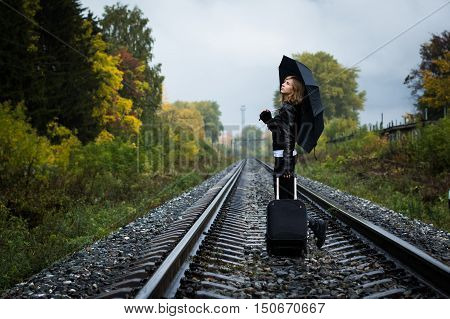 Girl, Umbrella And Rails In Autumn Day