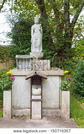 Kyoto Japan - September 15 2016: At the Shinnyo-do Buddhist Temple the statue of Kwan Yin the most important female in Buddhism stands in the garden. She is the avatar of bodhisattva Avolikiteshvara.