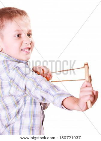 Nature and free time prankster little boy. Child have fun with wooden sling shot and fruit aim mandarine.
