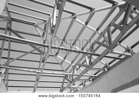 Black and white photoStructure of steel roof frame for building construction.The advantage of this structure is lightweight but strong.