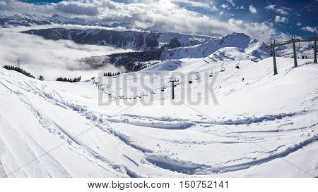 Kitzbuehel, Austria, February 17, 2016 - Skiers On Ski Lift Enjoying The View To Foggy Alps In Austr