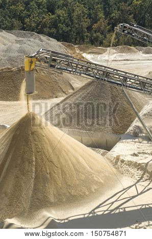 Working belt conveyors and a piles of rubble and stone meal in Gravel Quarry