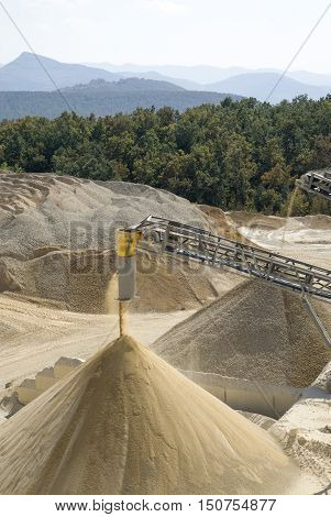Working belt conveyors and a piles of rubble and stone meal in Gravel Quarry