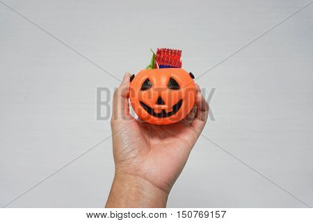 woman hold a bucket Jack-O-Lantern pumpkin full of candies