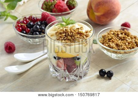 Dessert with fresh berries granola and custard in glasses