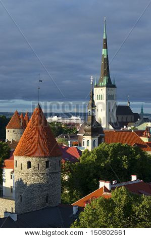The old Oleviste Church and the defensive tower under a cloudy sky. Historical landmark of the Old Tallinn, Estonia