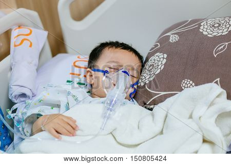 Asian little boy has sick sleep on bed in hospital. he needs fluid replacement.