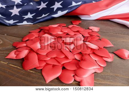 Many red hearts and USA flag, on a wooden table.Celebration, Love, patriotism.