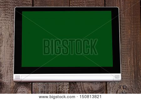 Tablet with isolated screen on the brown wooden table.