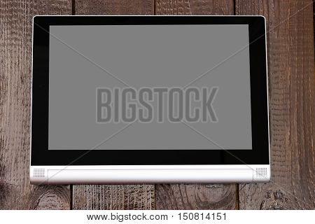 Tablet with isolated screen on the brown wooden table.