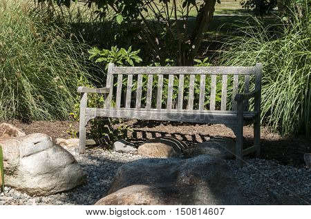 Empty old weathered wooden bench in park