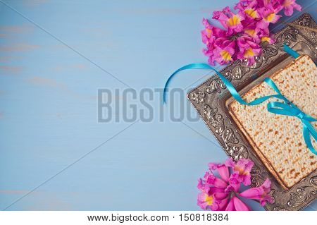Passover spring holiday background with matzoh and flowers. View from above