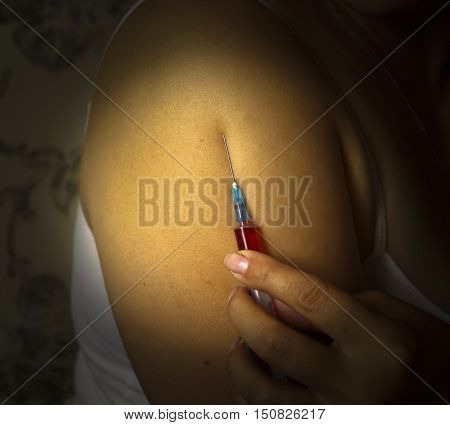 Stabbing drugs. the syringe and the hand enters injections, drugs, doping.