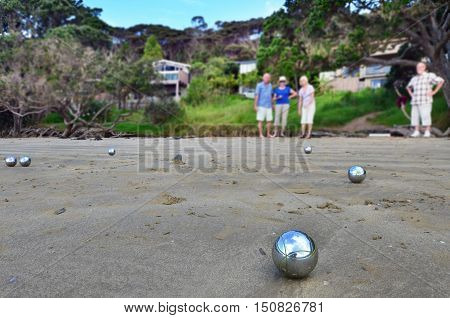 Senior people playing petanque on the beach.