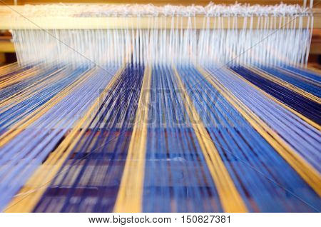 An home made loom colorful threads on a machine.