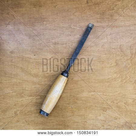 old rusty chisel isolated on a wooden background