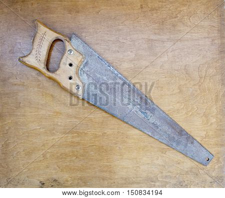 Rusty crosscut hand saw handsaw tool on wooden background