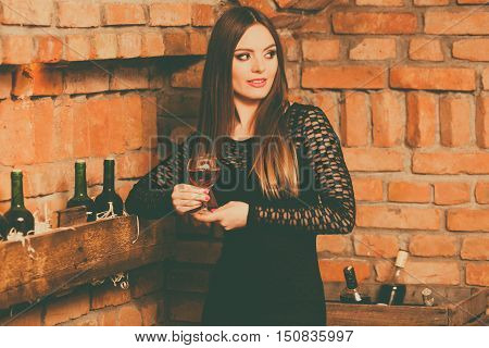 Woman Tasting Wine In Rural Cottage Interior