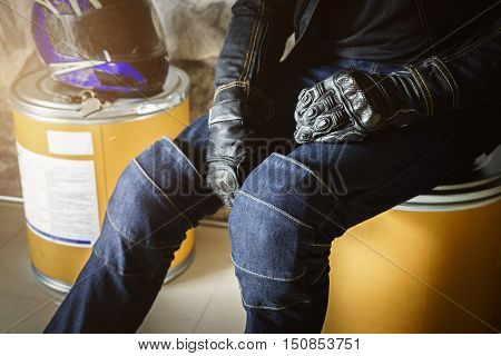 Biker man wearing jeans and leather jecket with helmet and glove