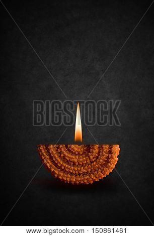 happy diwali or happy deepawali greeting card made by showing diya made up of  maharashtrian famous recipe called chakali with diya flame, season's greetings