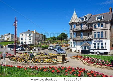 SEATON, UNITED KINGDOM - JULY 18, 2016 -Pretty flowerbeds on a traffic island with town buildings to the rear Seaton Devon England UK Western Europe, July 18, 2016.