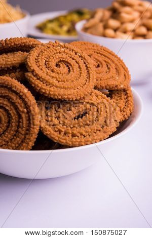 home made tasty Diwali food or Diwali snacks or Diwali sweets like rava laddu, chakli, sev,shankar pale and chivda or chiwada with dry fruits in white bowls, favourite indian diwali recipe