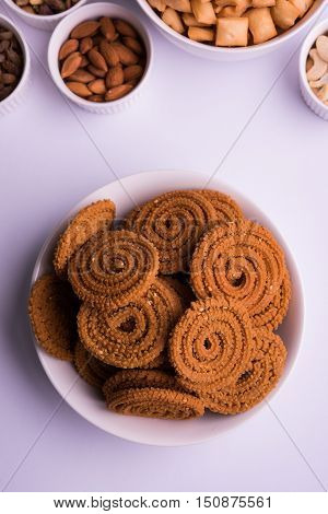home made tasty Diwali food or Diwali snacks or Diwali sweets like rava laddu, chakli, sev,shankar pale and chivda or chiwada with dry fruits in white bowls, favourite indian diwali recipe
