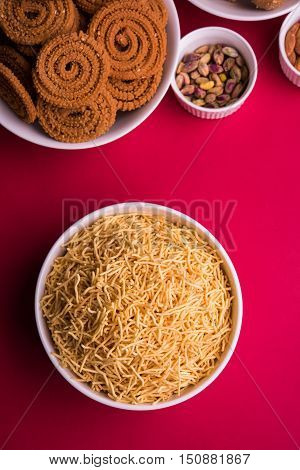homemade tasty Diwali food or Diwali snacks or Diwali sweets like rava laddu, chakli, sev, shankar pale and chivda or chiwada with dry fruits in white bowls, favourite indian diwali recipe