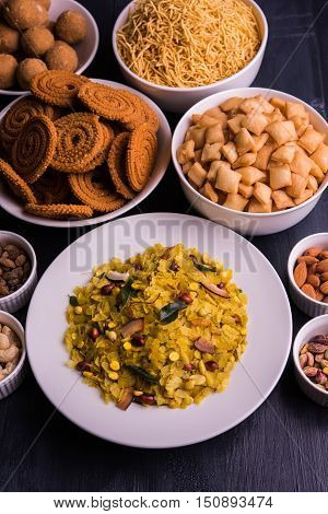 homemade tasty Diwali food or Diwali snacks or Diwali sweets like rava laddu, chakli, sev, shankar pale and chivda or chiwada with dry fruits in white bowls, favourite indian diwali recipe