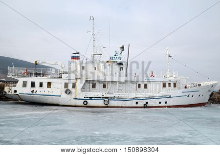 Lake Baikal, Russia - March 21, 2016: Ship and fisher boats on the dock in Large Goloustnoye Village. Russia Baikal Lake.